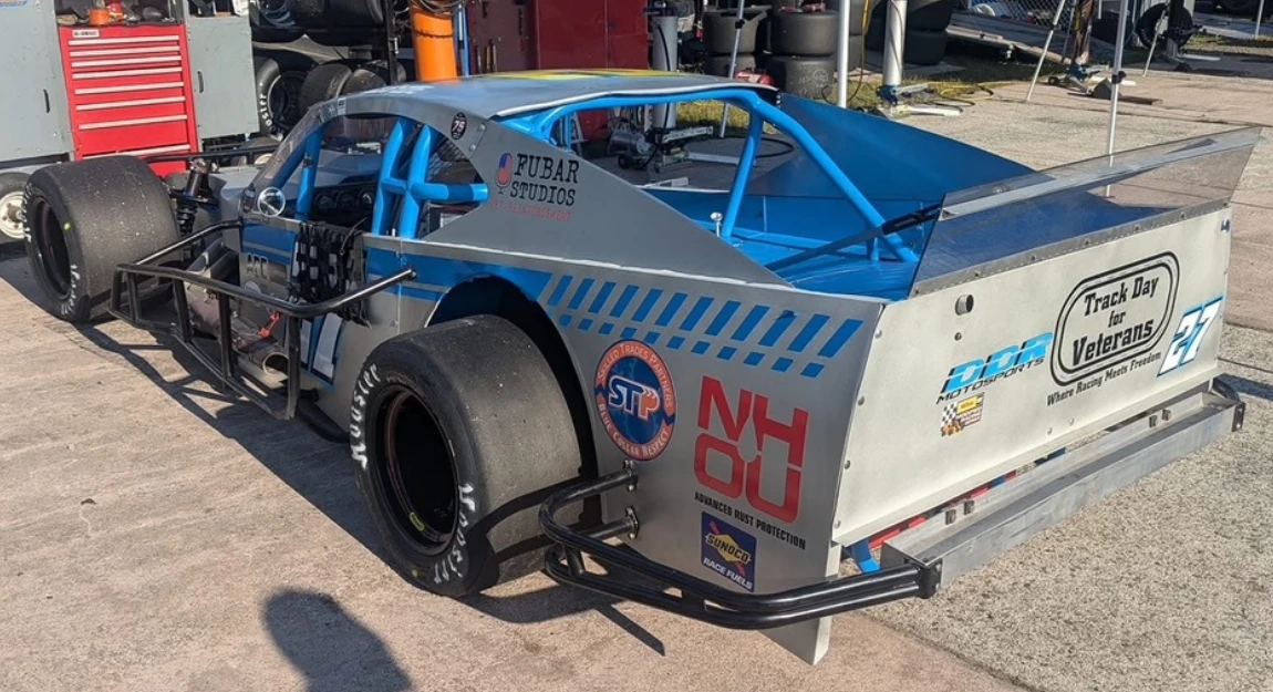 DDR Motorsports 57 Modified race car featuring NH Oil Undercoating 10-year partnership branding and Track Day for Veterans program logo